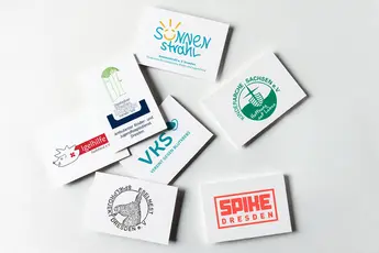 Visitenkarten auf grauer Fläche mit Logos